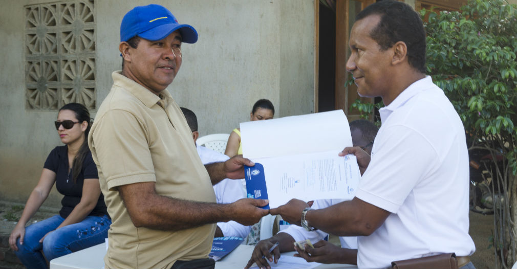 Un propietario recibiendo su escritura. 