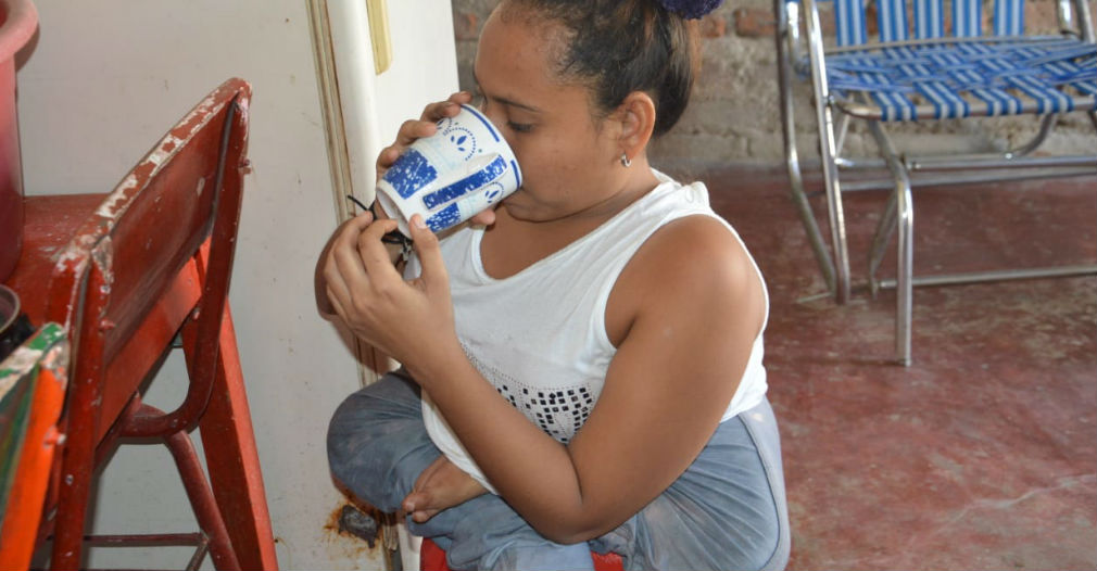 Después de barrer, Katherine se sirve un vaso con agua.