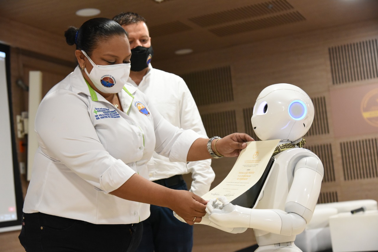 De manera simbólica y en representación de los graduados homenajeados, las medallas y pergaminos honoríficos fueron entregados al Robot Lied.