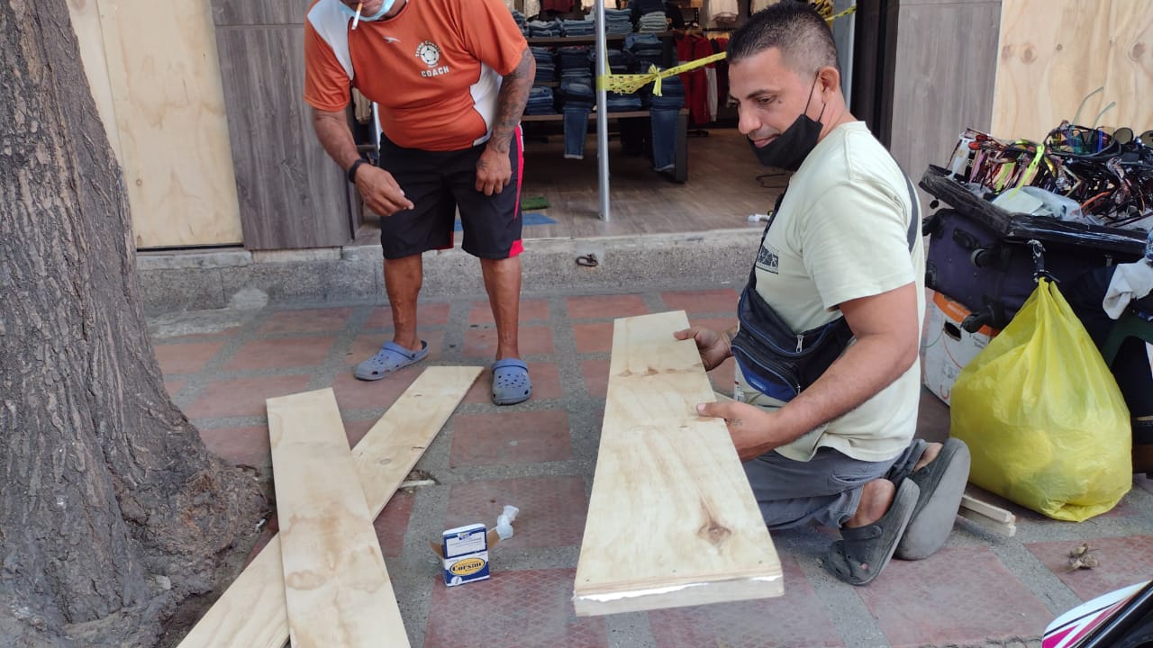 Comerciantes están cubriendo los ventanales para evitar desmanes. 