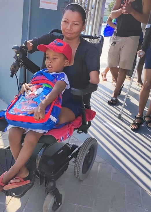 Con su hijo y su silla de ruedas, Virgelina demuestra que nada le queda grande.