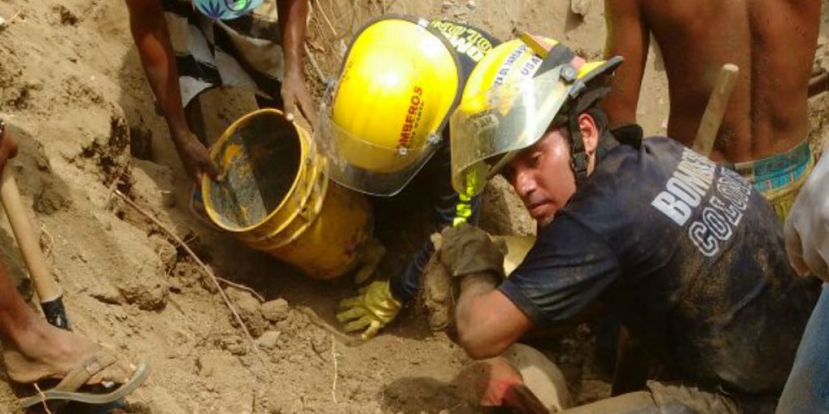 Socorristas tratando de rescatar el cuerpo con la ayuda de la comunidad.