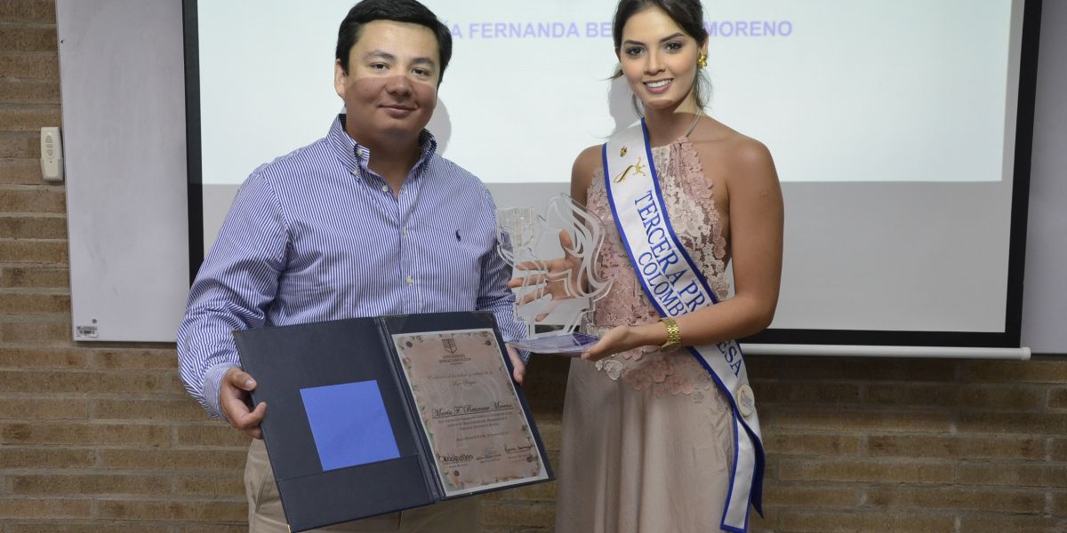 María Fernanda Betancur recibiendo el reconocimiento de manos del subsecretario general de la Universidad Sergio Arboleda, Juan Pablo Santrich.