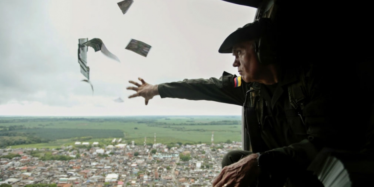 El comandante de la Policía Antinarcóticos, José Mendoza, lanza volantes informativos desde un helicóptero