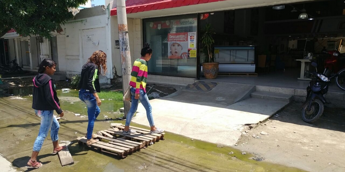 Personas se arriesgan a pasar por los improvisados senderos peatonales.  