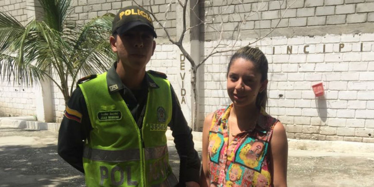 El patrullero Jean Romero (izq) junto a la joven que perdió y recuperó su dinero.