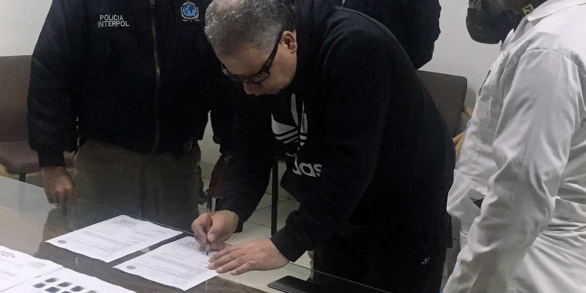  Exjefe paramilitar Daniel Rendón Herrera firmado documentos durante su extradición.