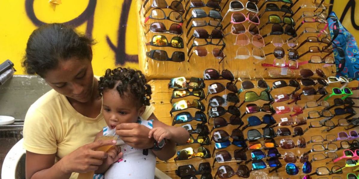 Denis lleva a su hija a su puesto de gafas porque no tiene con quién dejarla.