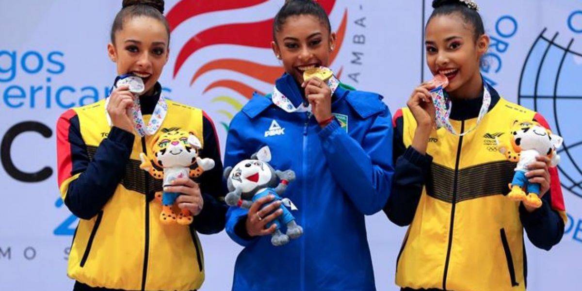  La gimnasta brasileña Bárbara Godoy Domingos (c), y las colombianas Lina Dussan (i) y Oriana Viñas (d) posan durante la ceremonia de premiación de las competencias de gimnasia rítmica.