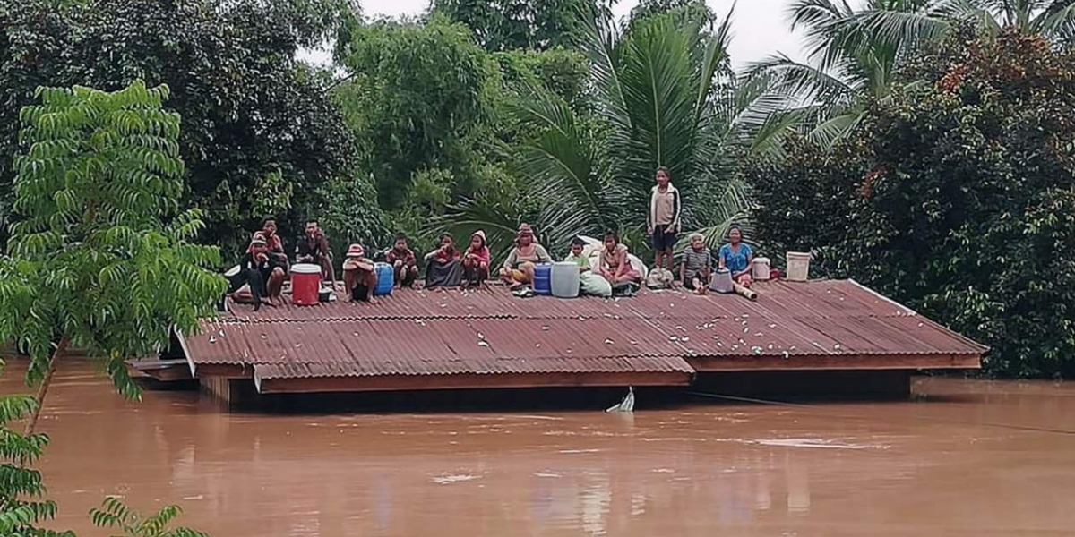  Un grupo de personas aguarda en lo alto de un tejado en una zona inundada tras el derrumbe de una presa hidroeléctrica en un pueblo cercano a la provincia de Attapeu, en Lao.