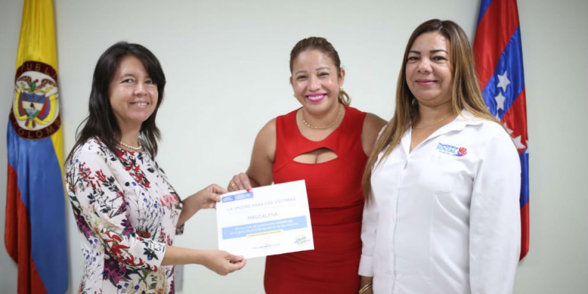 Norma Vera recibiendo el reconocimiento entregado por la Unidad de Víctimas.