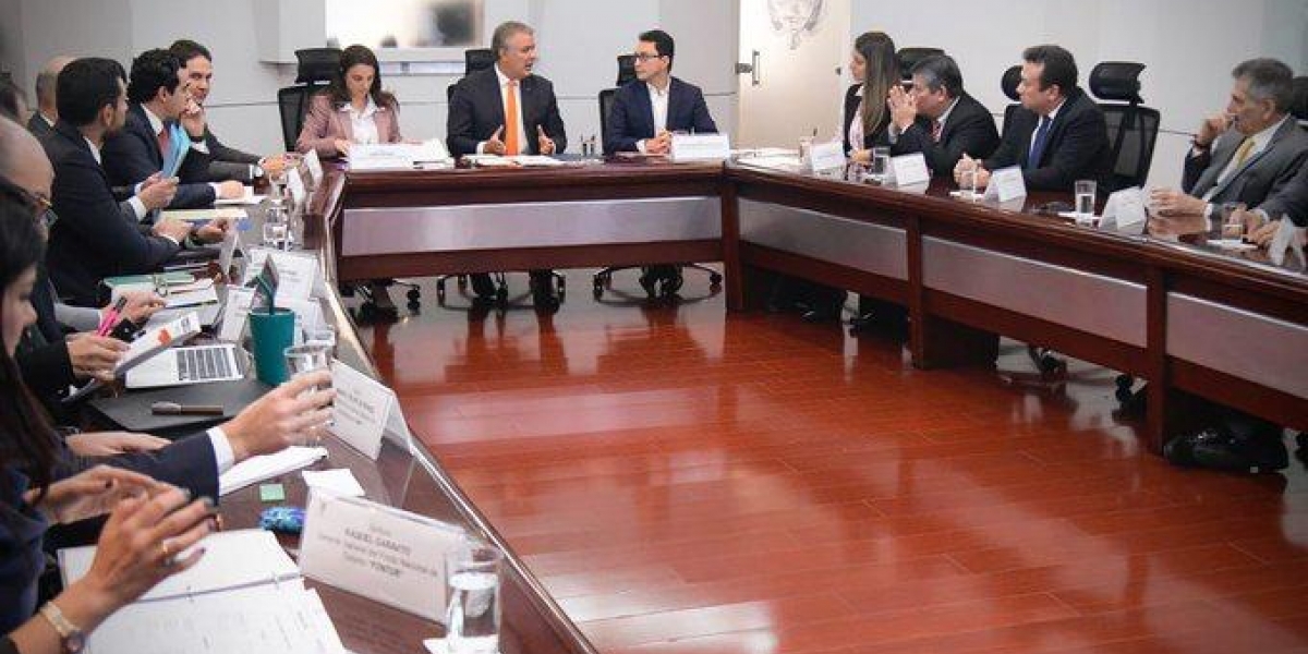 Carlos Caicedo sentado junto al presidente Iván Duque en un encuentro en Casa de Nariño.