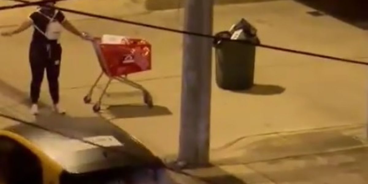Momento en que la mujer buscaba un taxi con la mercancía hurtada.