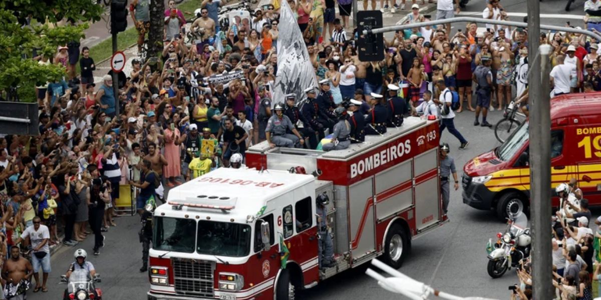 Cortesía. Decenas de personas sigue el camión de bomberos con los restos del astro de Brasil.