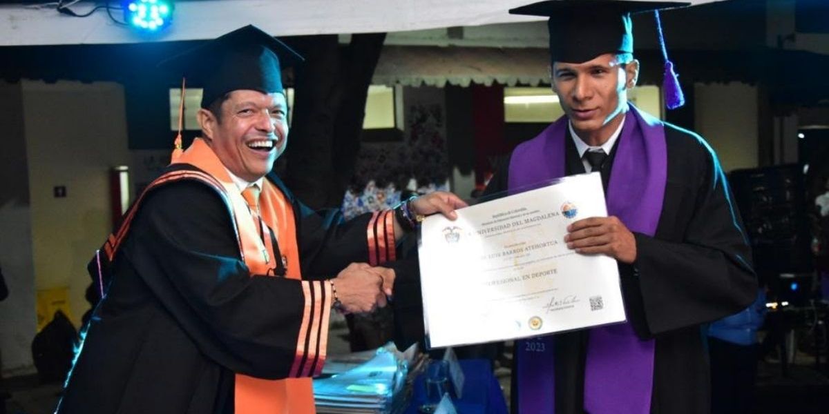 José Luis Barros recibiendo diploma por el rector Pablo Vera