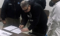  Exjefe paramilitar Daniel Rendón Herrera firmado documentos durante su extradición.