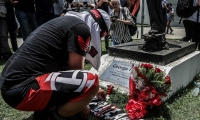 Un hombre pone flores en homenaje a las víctimas del incendio registrado en la madrugada de este viernes, en el centro de entrenamiento del club de fútbol Flamengo.