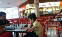 En la foto se ven las mesas vacías mientras los niños juegan ajedrez.