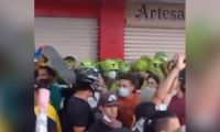 Momento en que los jóvenes protegen al grupo de policías.