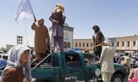 Los combatientes talibanes festejan la conquista de Kandahar sobre un vehículo de la Policía