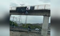Pancartas y muñeco en el puente peatonal.