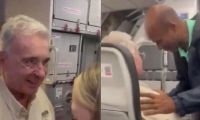 Álvaro Uribe recibiendo saludos en el avión.