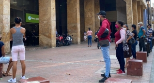 Personas en bancos de Santa Marta.