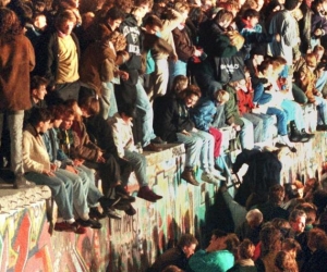Jóvenes sobre el Muro de Berlín.