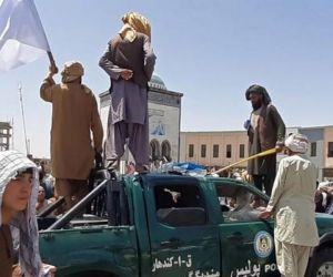 Los combatientes talibanes festejan la conquista de Kandahar sobre un vehículo de la Policía