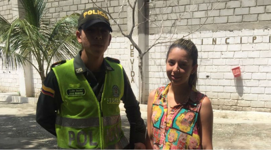 El patrullero Jean Romero (izq) junto a la joven que perdió y recuperó su dinero.