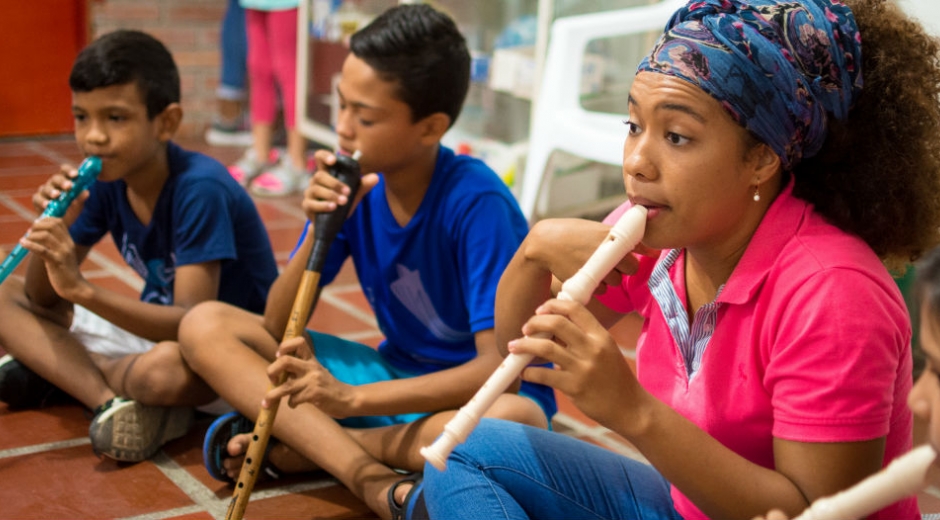 Niños recibiendo clase de musica