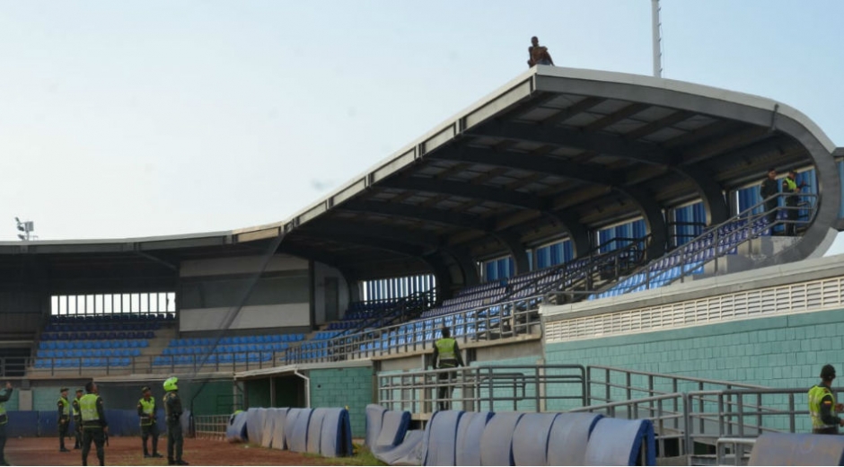 Hombre subido en el techo del estadio de beisbol.