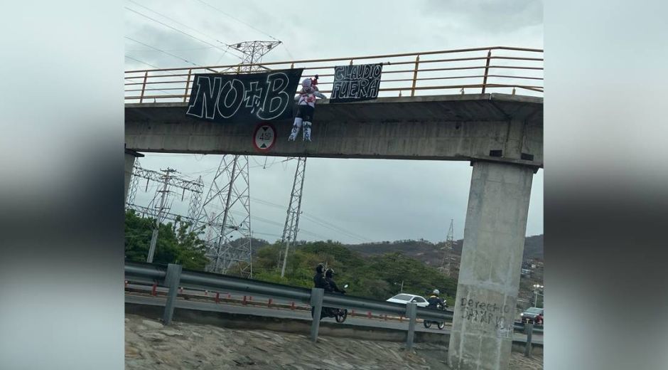 Pancartas y muñeco en el puente peatonal.