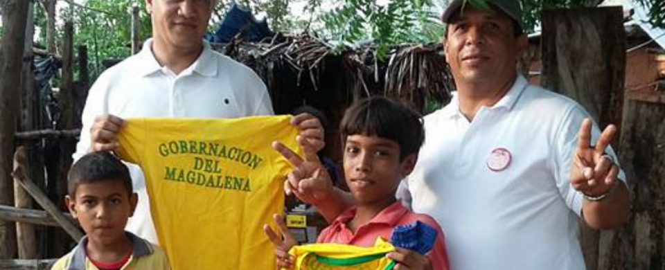 El jefe de la campaña de Eduardo Villa posa con niños que recibieron camisetas de la Gobernación del Magdalena.
